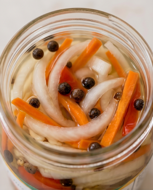 open jar showing vegetables in sauce